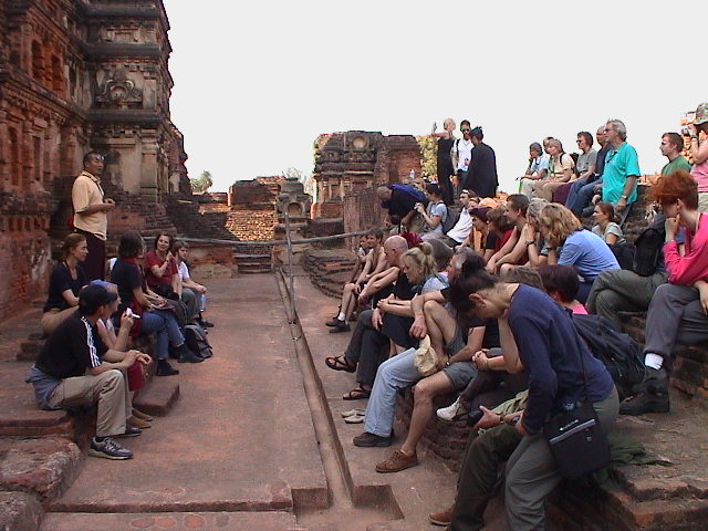 people sitting on the steps at an ancient city