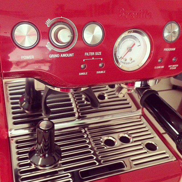 a red coffee machine sitting on top of a counter