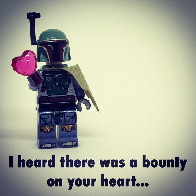 a lego figure holds a pink heart on its arms