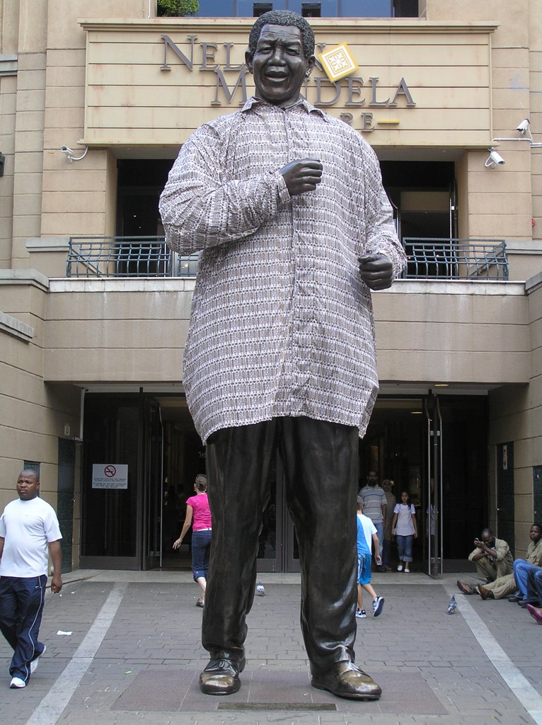 the statue is outside of a building on a sunny day