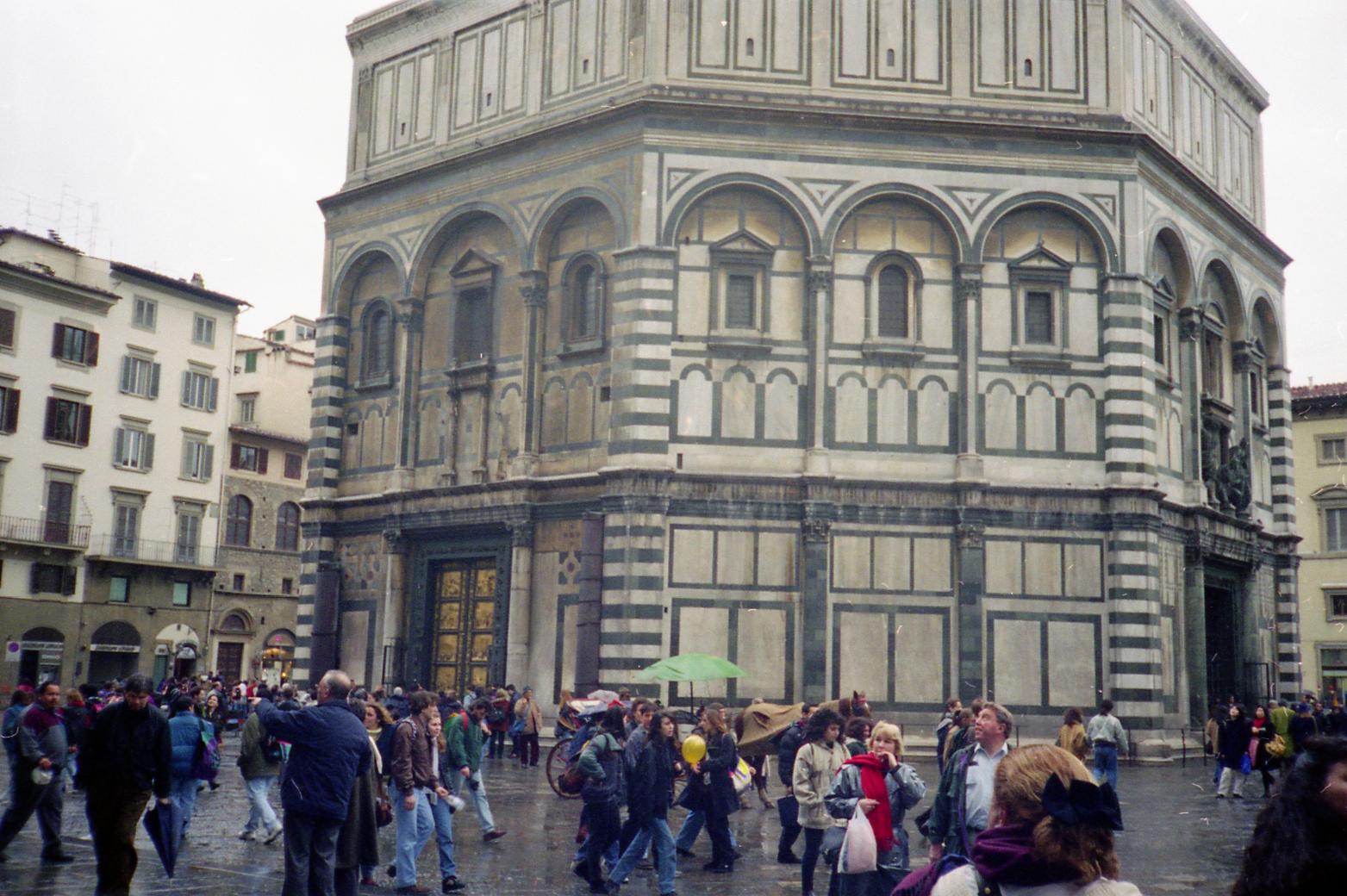 people walking in a wet square in the rain