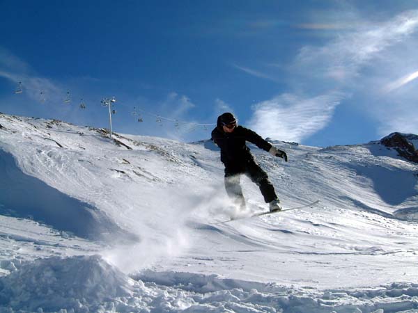 a person riding a snow board down a snow covered slope