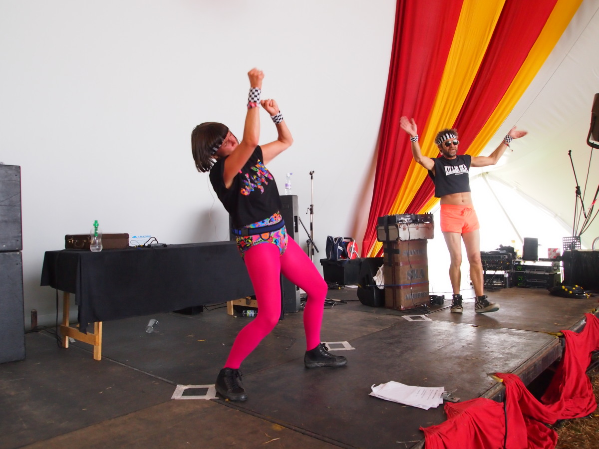 two women performing on stage in front of microphones