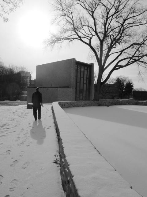 man walking away from a building, in winter time