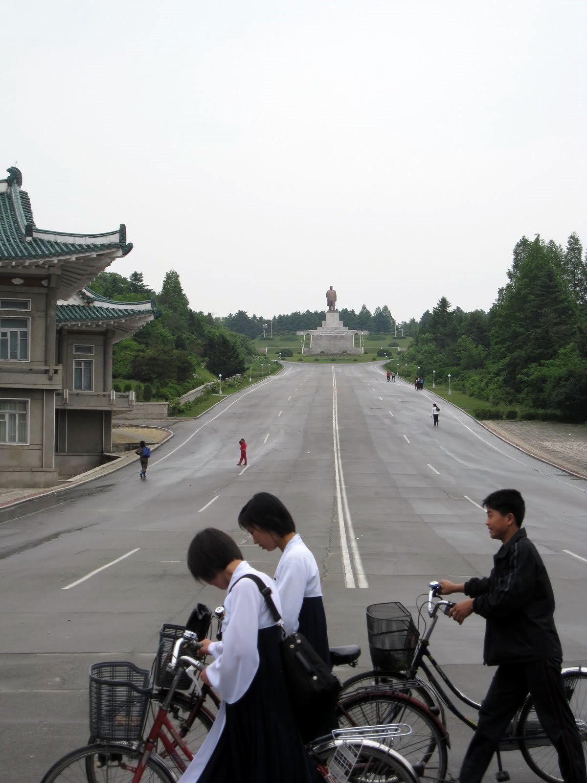 a man and two girls riding bikes on a street