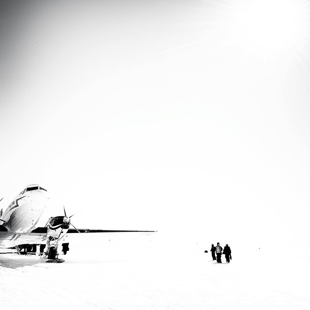 black and white pograph of an airplane parked at an airport