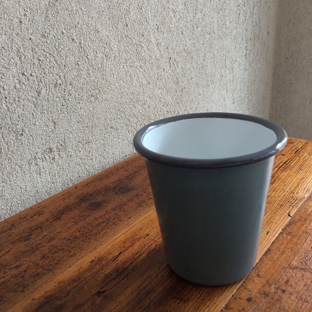 a black and white cup on wooden counter