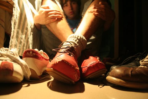 a man sitting on a counter next to a bunch of shoes