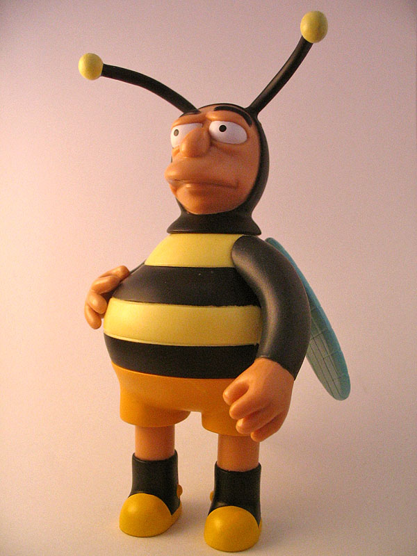 a bee figurine standing on top of a white surface