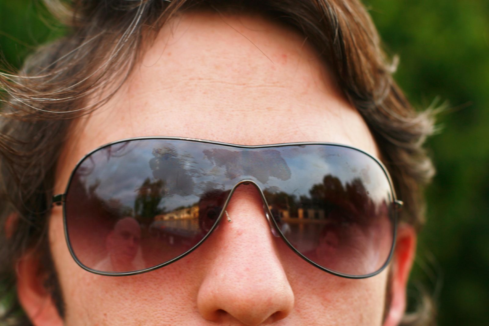 a man with a pair of sunglasses reflecting his image