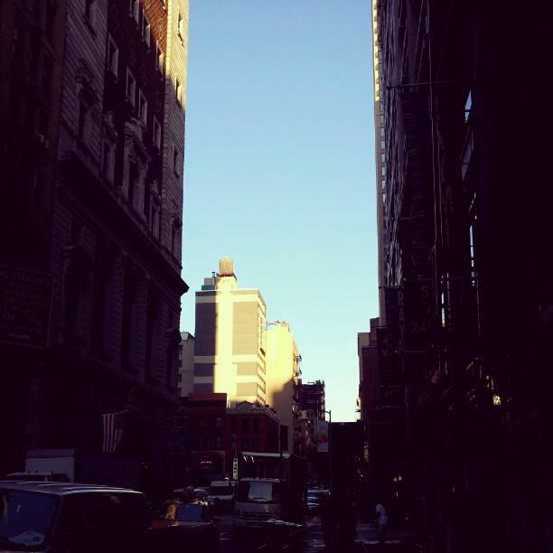 a back alley is lined with buildings and cars