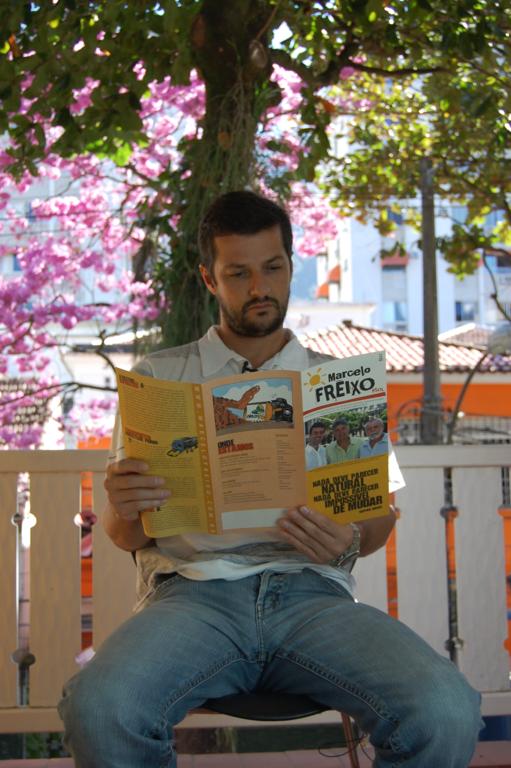 a man in jeans sits on a bench reading a book