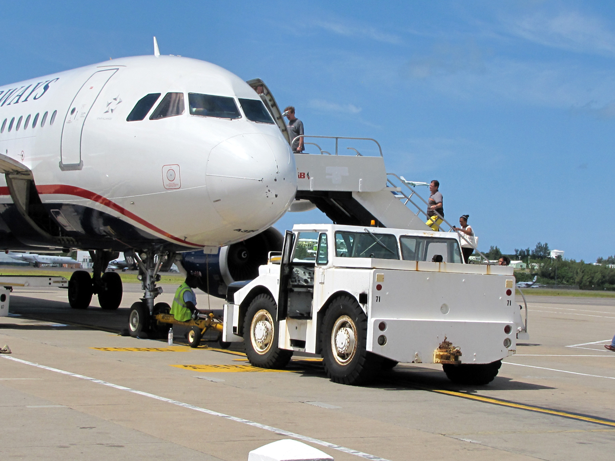 a vehicle towing an airplane across the tarmac