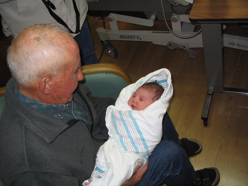 a man holding a baby who is wrapped in a sheet