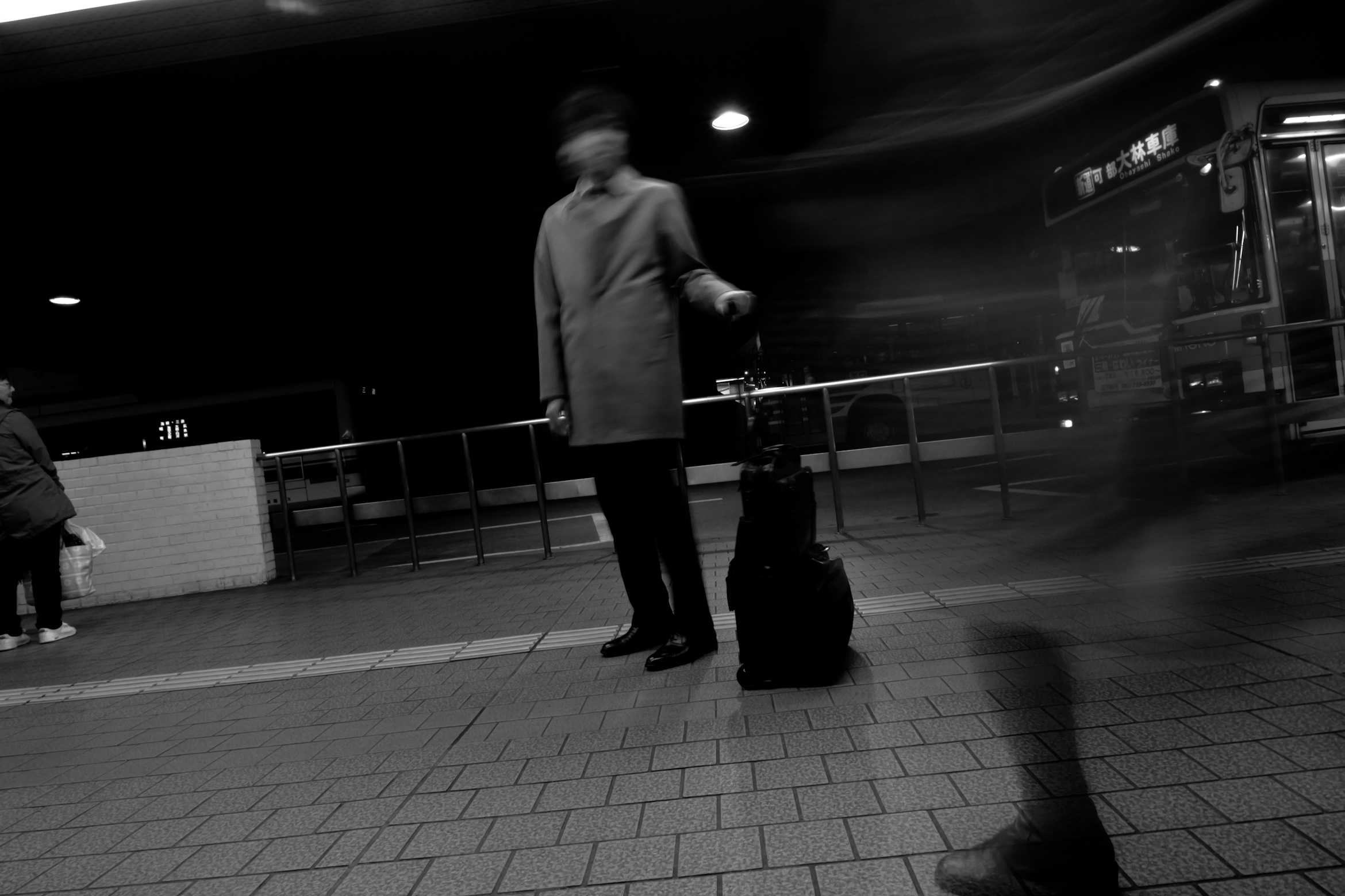 a man stands on a subway platform in the dark