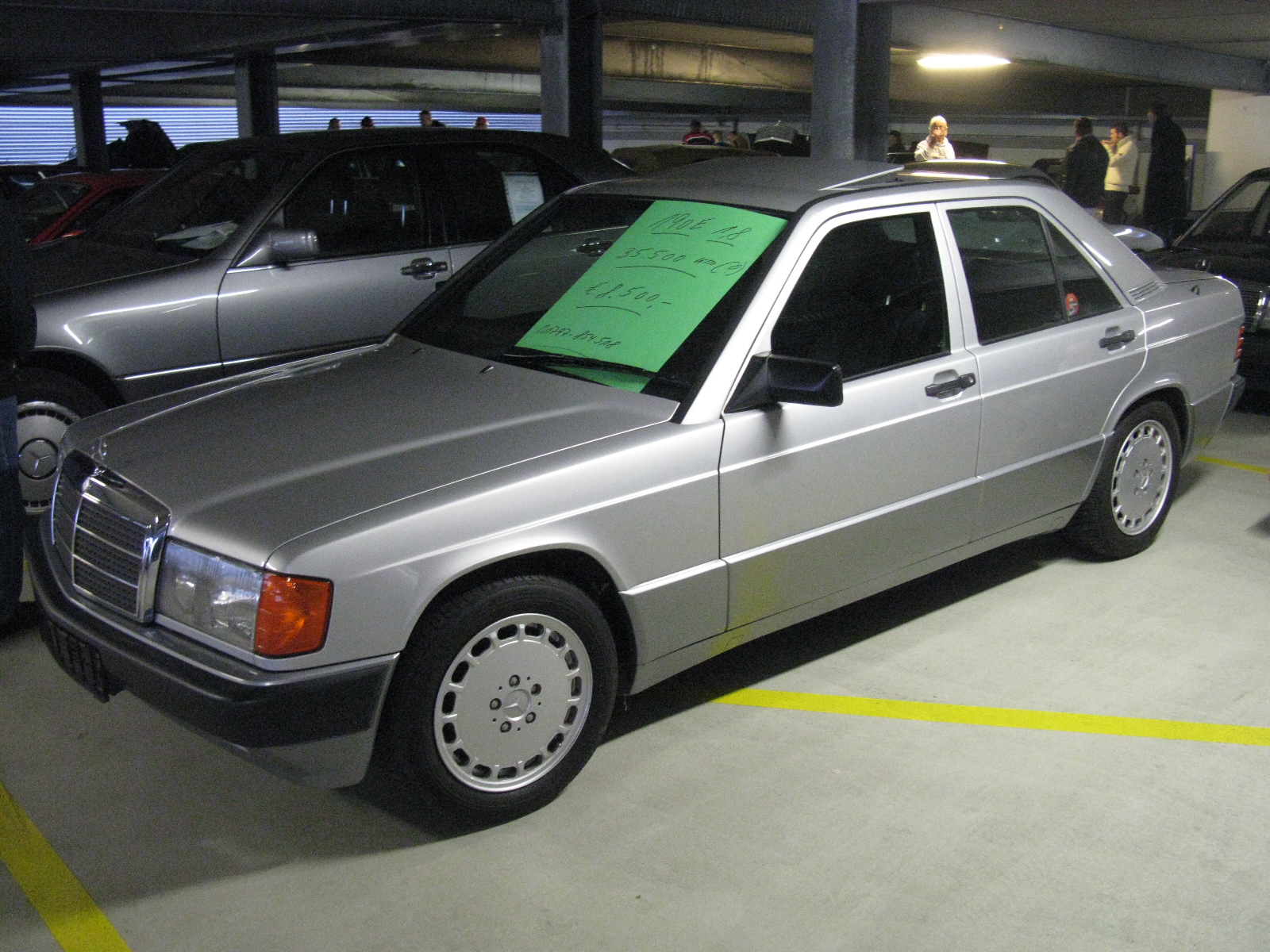 a car parked in a garage with green post - it notes on the roof