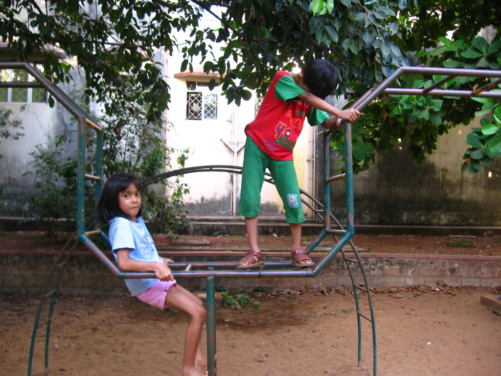 a boy and a girl are climbing up and down a spiral shaped climber
