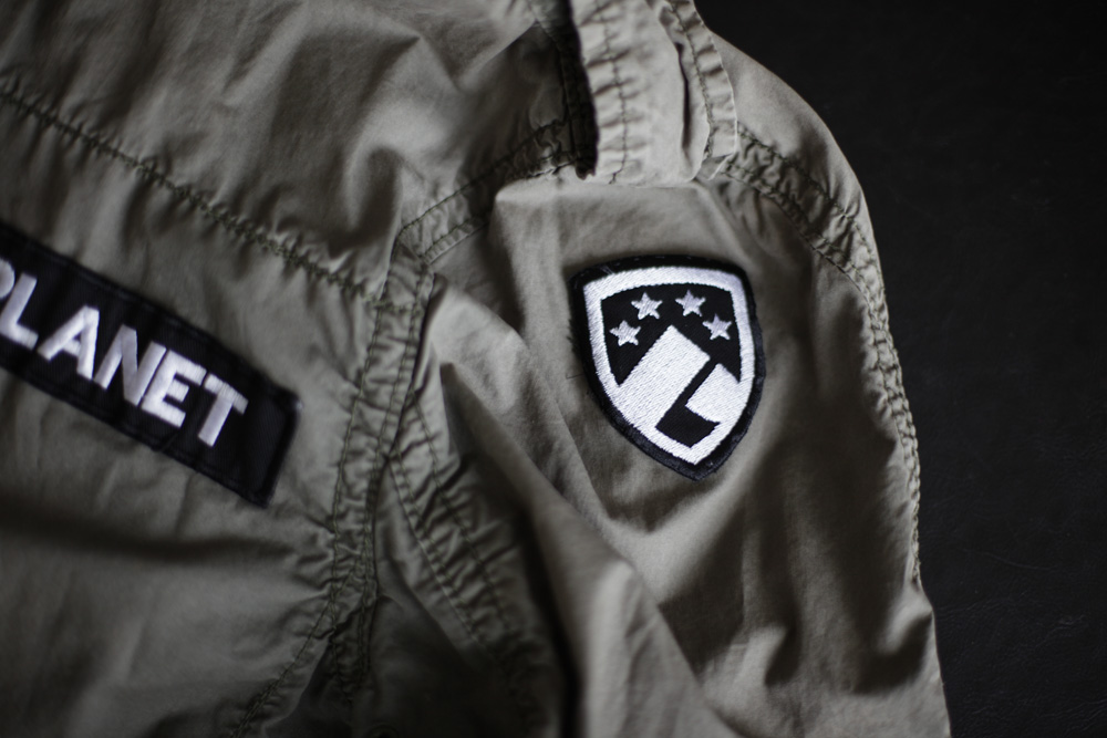an emblem on the chest of a coat that says planet