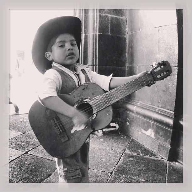 a little boy with a cowboy hat and guitar