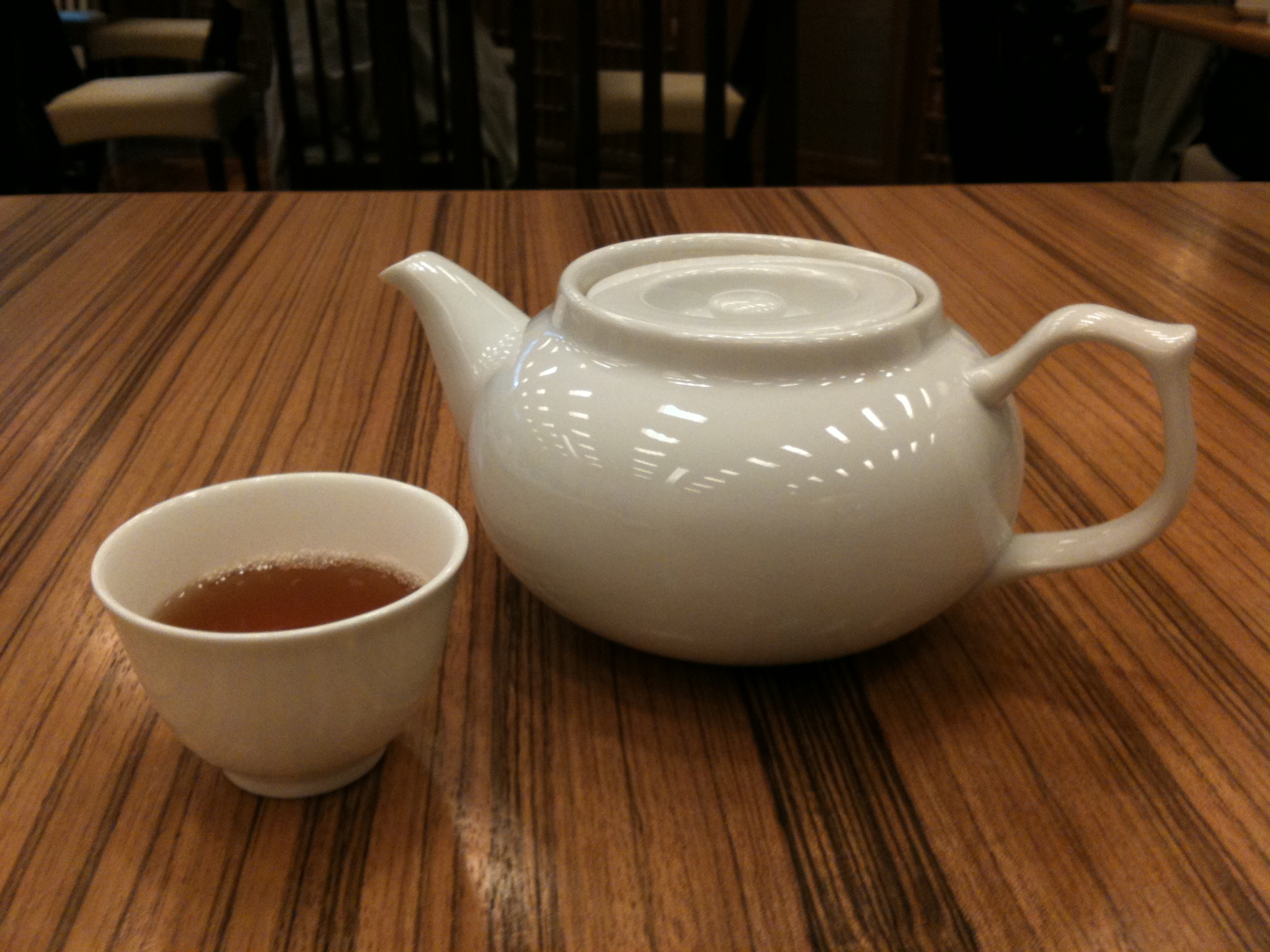 a tea pot sitting next to a cup on a table
