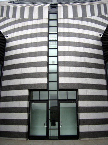 a building with black and white striped walls next to a clock