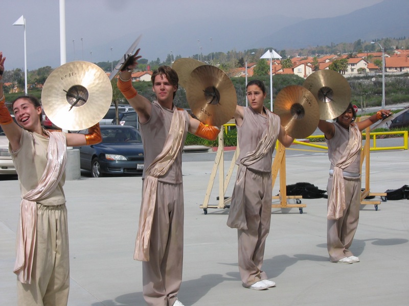 people in costumes holding large, gold discs