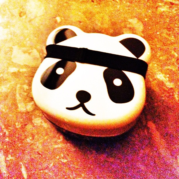 there is a small ceramic panda bear that has an blindfold on it