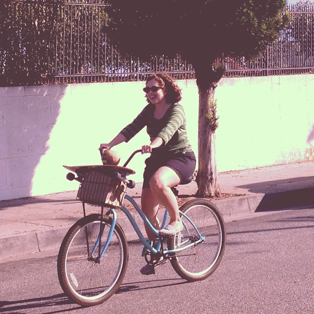 woman riding bicycle on street with basket in basket