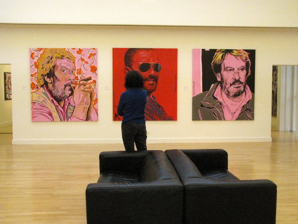 a person stands in front of some large paintings