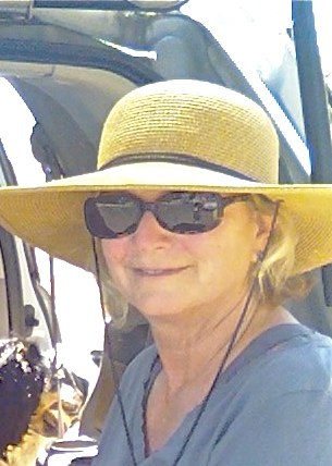 a woman is wearing a straw hat and sunglasses in front of a truck