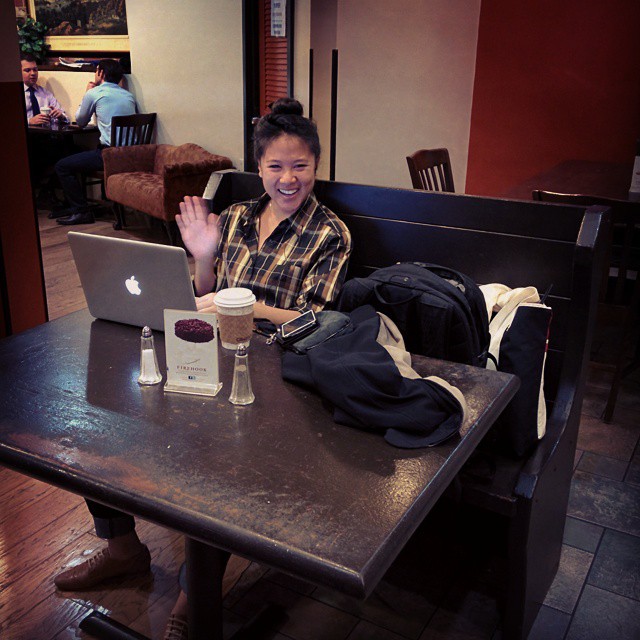 a person sits at a table with a laptop and snacks