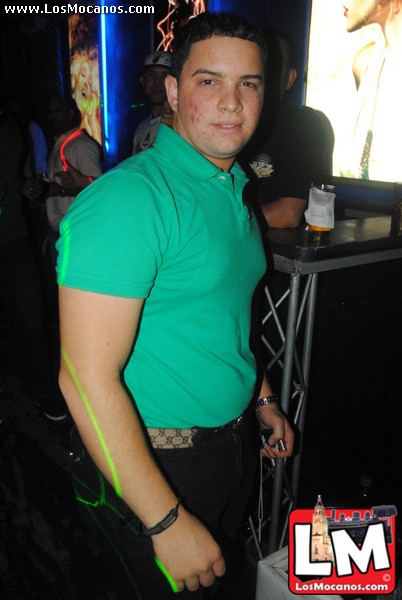 a man posing for the camera while wearing a green shirt