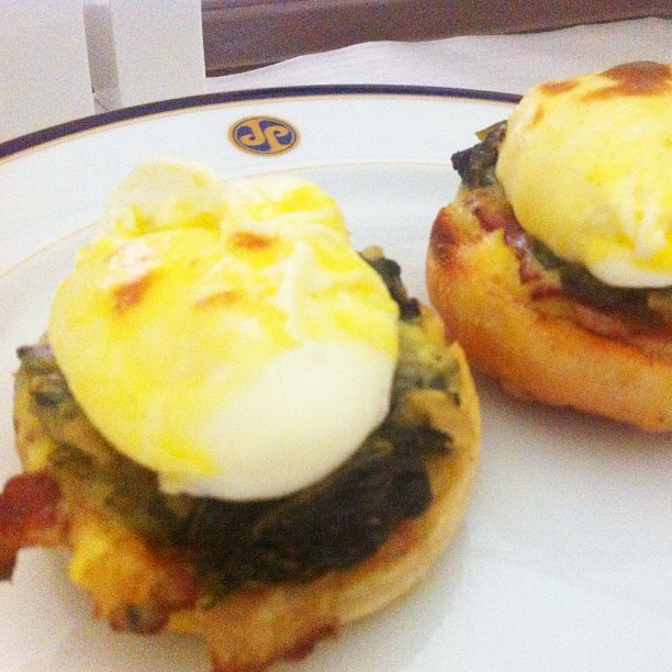 eggs are being served on bread buns with spinach