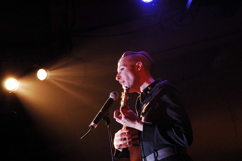 a man holding a microphone on top of a stage