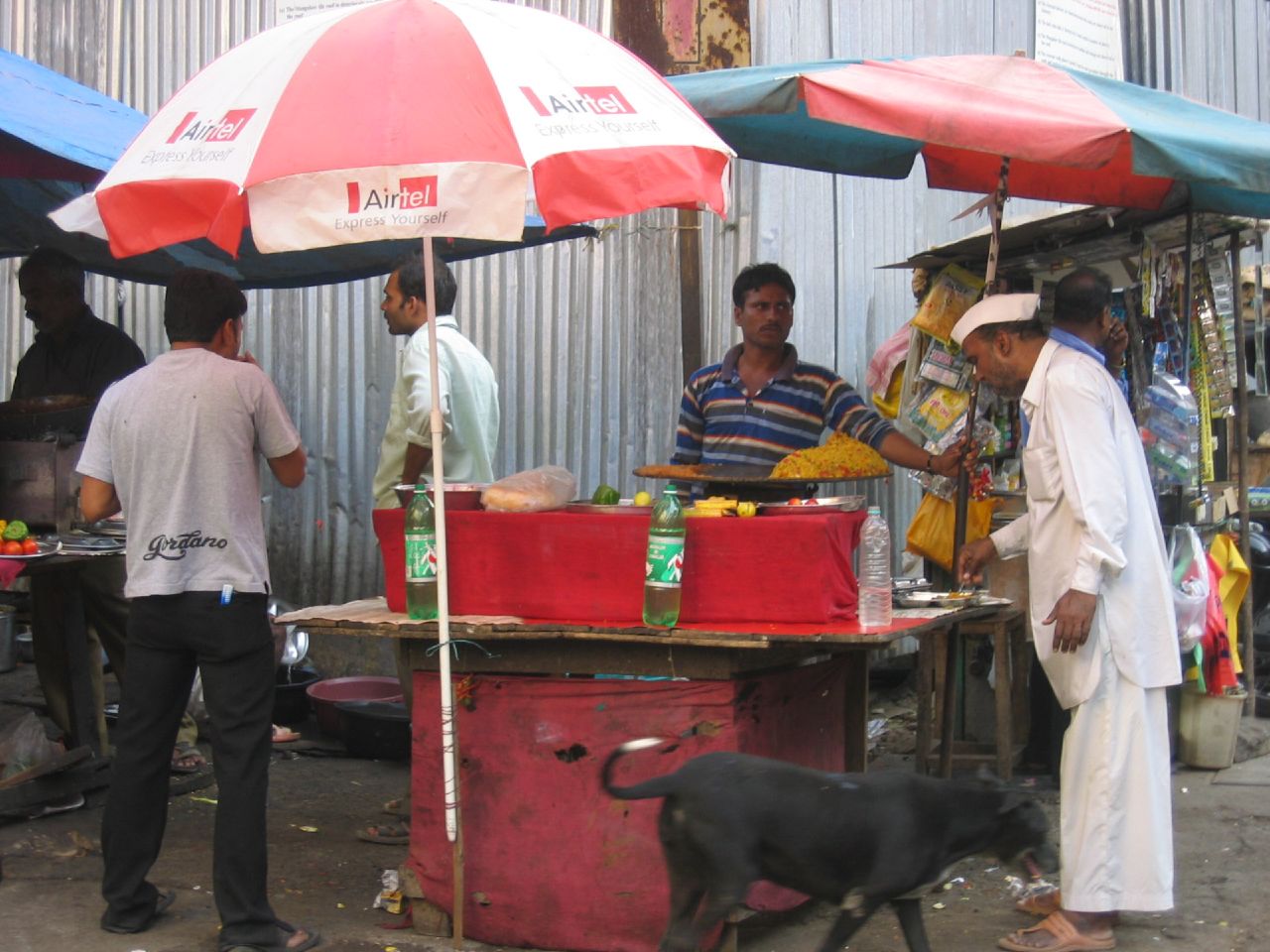 a man is standing behind his stall selling food