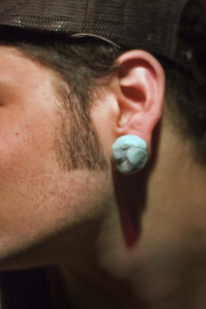 an ear piercing is seen on a man's head