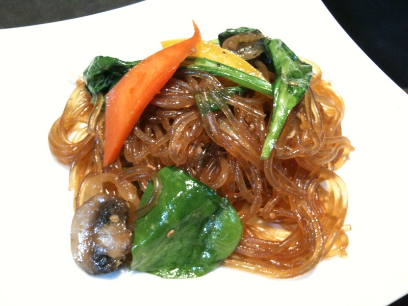 a plate filled with noodles and vegetables and carrot