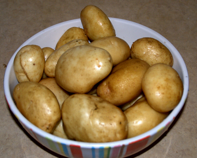a bowl filled with very large potato's on top of a table