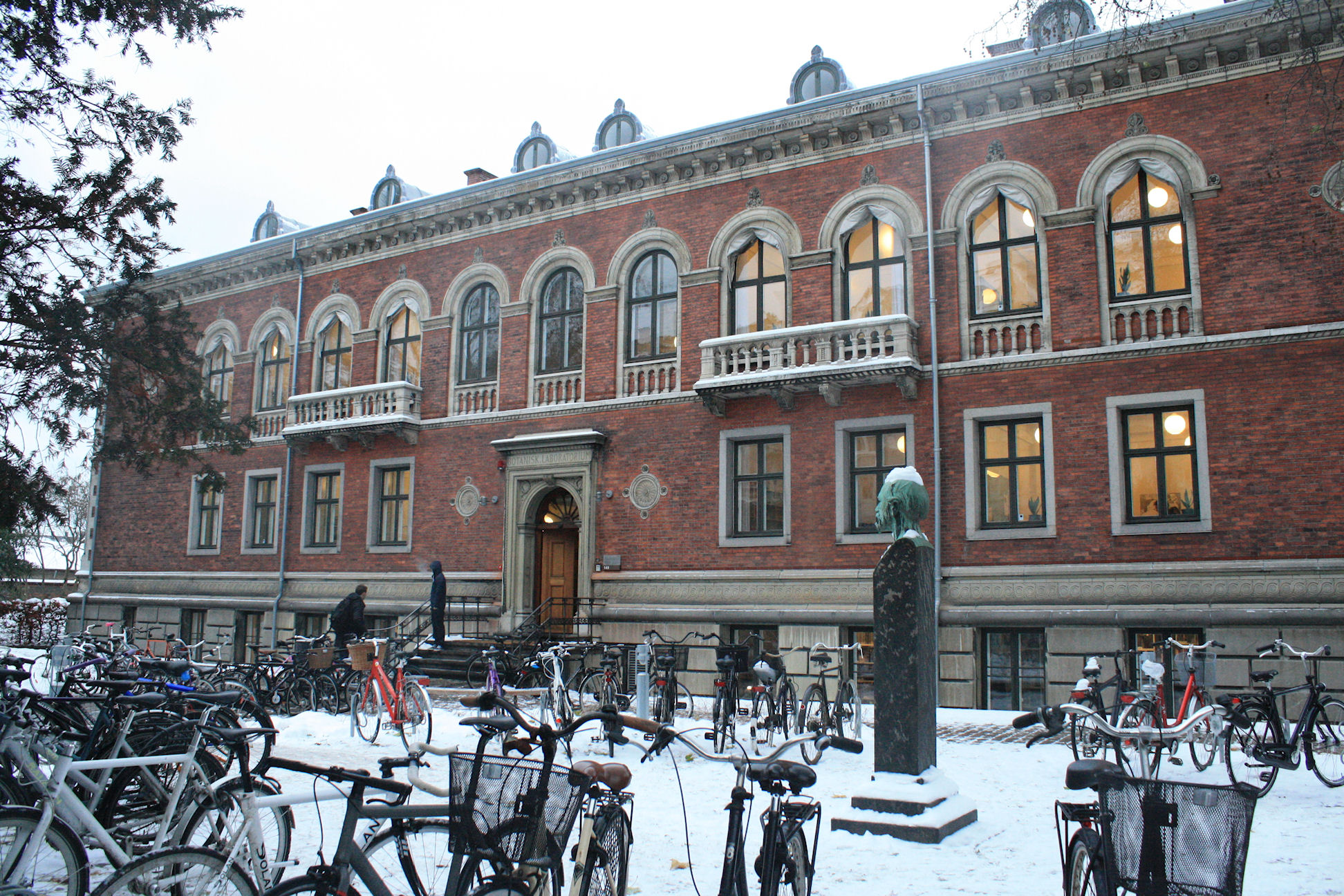 several bicycles are parked in front of a red brick building