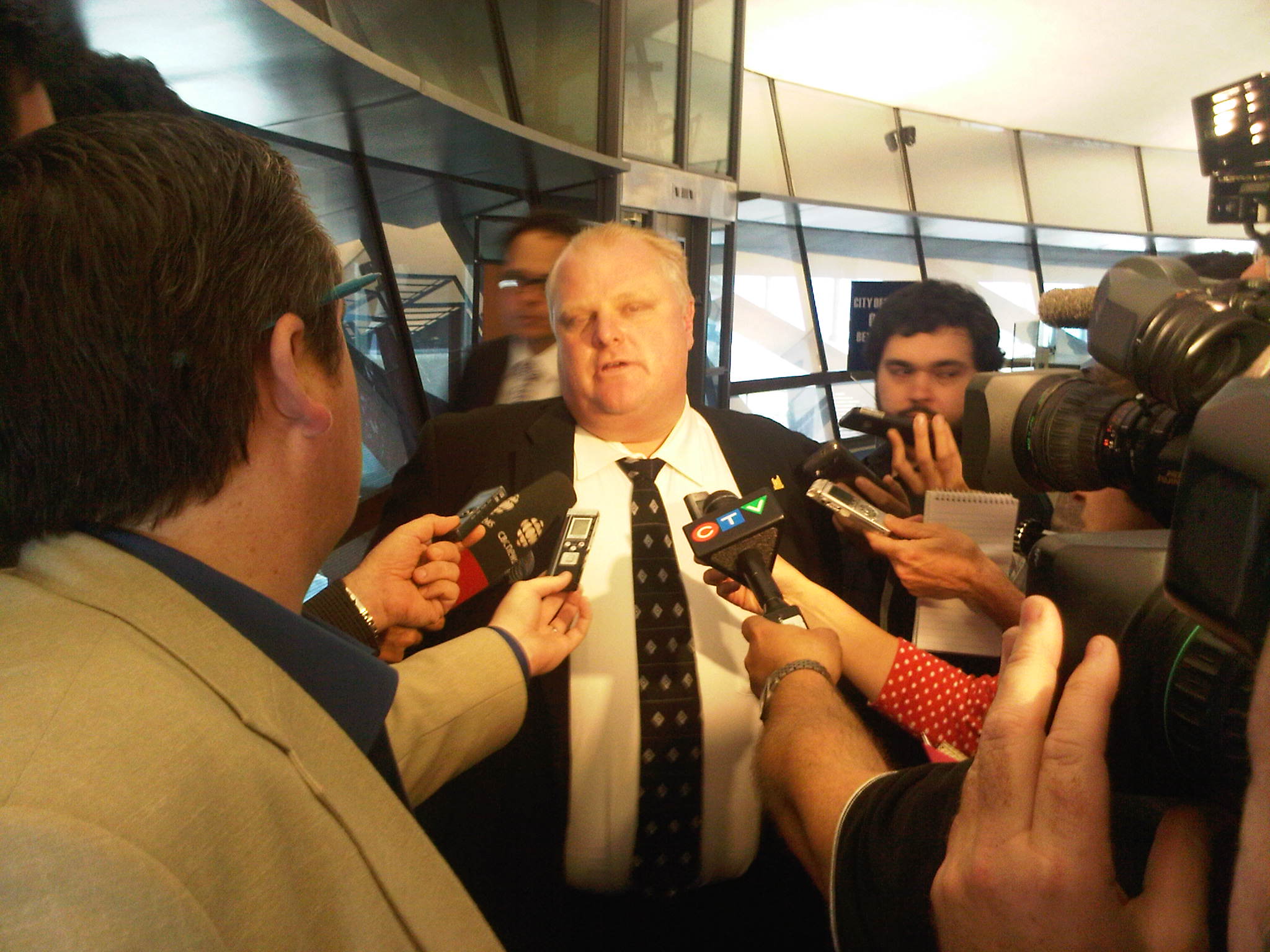 a man surrounded by journalists in a room