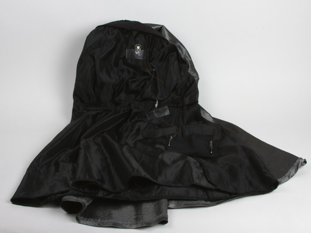 a large black rain coat laying on the floor