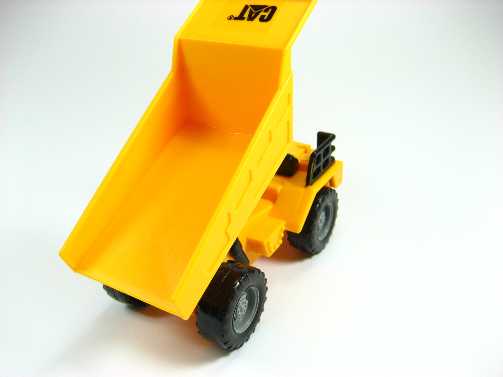 a toy dumper sits on a white surface