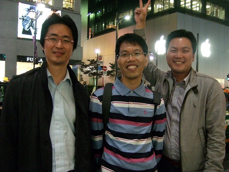 three men at an apple store holding up two fingers