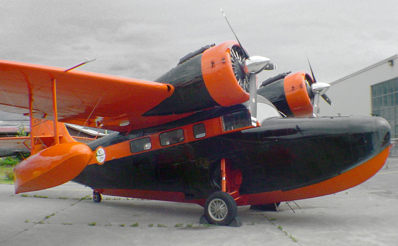 an orange black and white plane sits outside