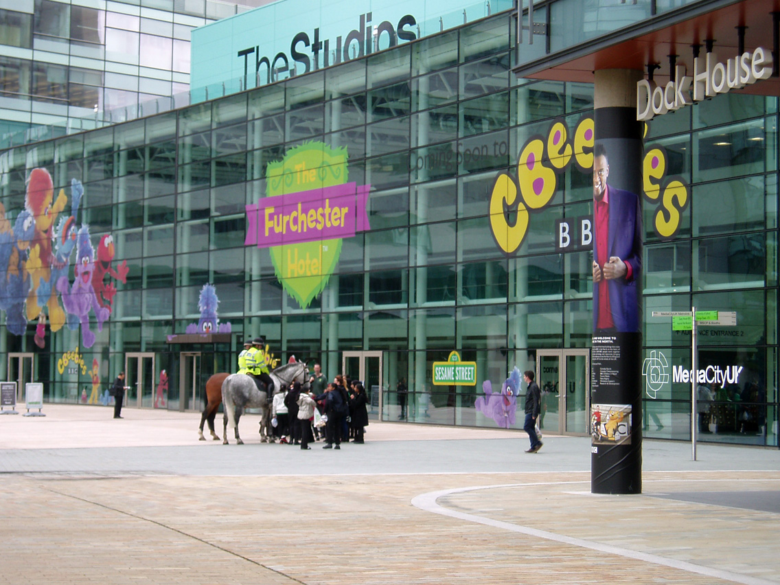 several people walk around in front of a large building