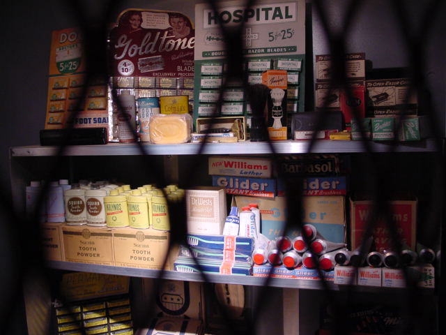 a shelf with many items behind a metal fence