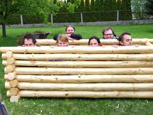 a group of people posing in a log bench