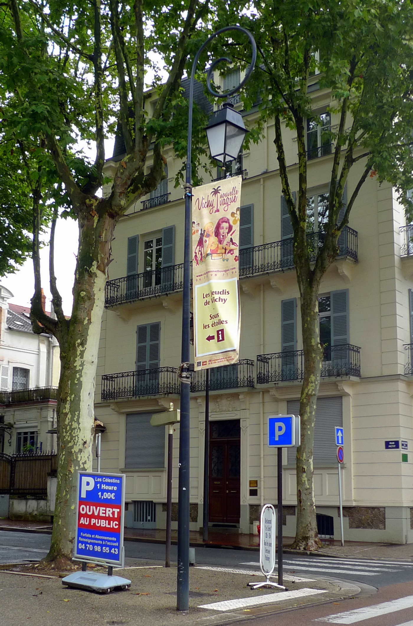 a tall beige building with windows and a street light