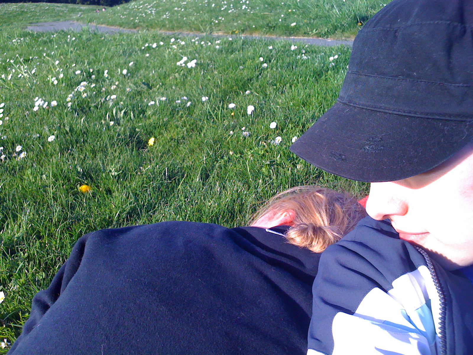 a person sitting on a grass covered field