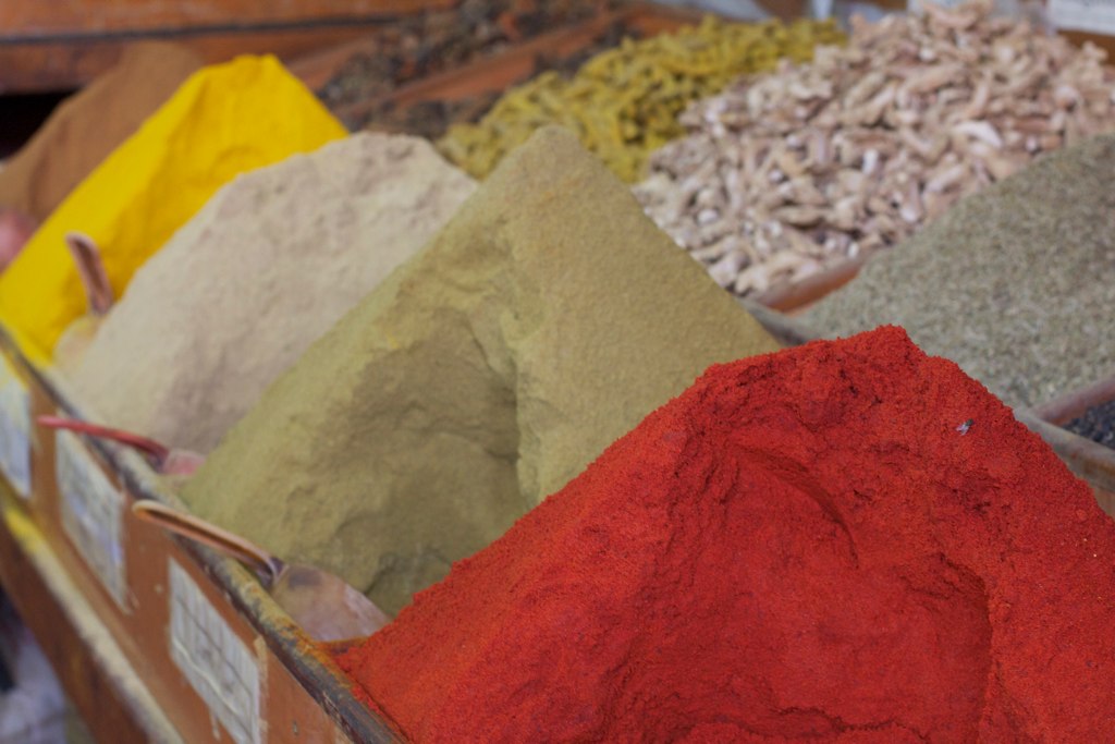 colorful spices and herbs are laid out in rows